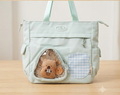 Mint green structured tote bag with triangular transparent bear window pocket and gingham patch detail